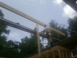 Carpenter setting a ridge beam over a new addition frame — Ice Dam Removal by Roofing Brothers in Elkins