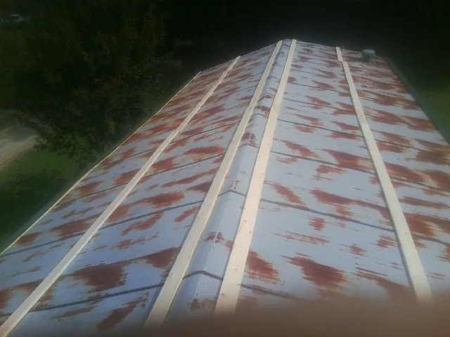 Rusted metal roof panels with new wood purlins before replacement — Storm Damage Roof Repair in Elkins by Roofing Brothers