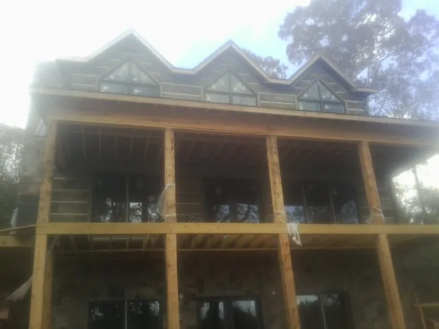 Dormers and porch framing on a large log home under construction — Roof Coating work by our crew in Elkins