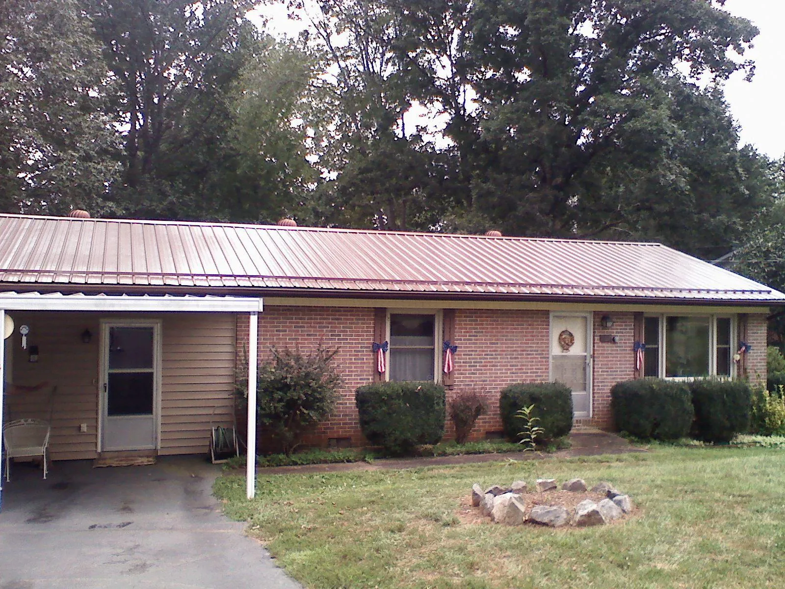Bronze metal roof and carport on a brick ranch home — Roof Repair work by our crew in Elkins